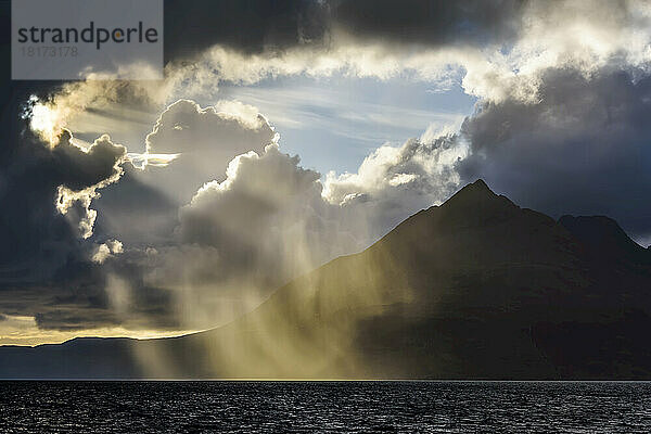Die Sonne bricht durch die dramatischen Wolken entlang der schottischen Küste über Loch Scavaig auf der Isle of Skye in Schottland  Vereinigtes Königreich