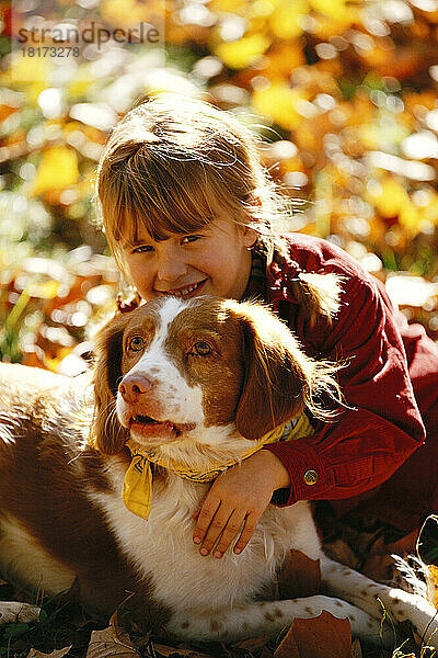 Porträt eines Mädchens  das einen Hund umarmt