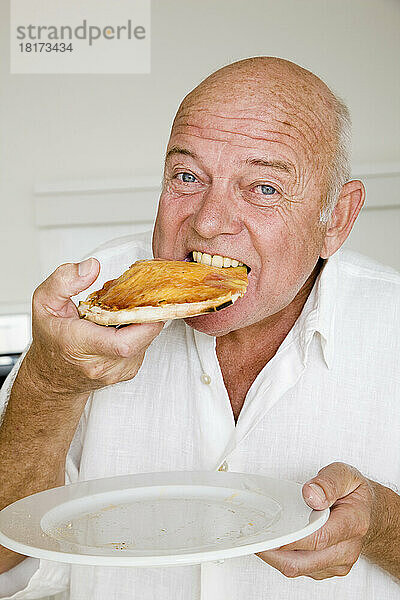 Porträt eines Mannes  der ein Stück Pizza isst