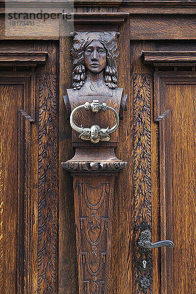 Nahaufnahme eines Türklopfers an einer dekorativen  geschnitzten Holztür  Cesky Krumlov  Tschechische Republik.