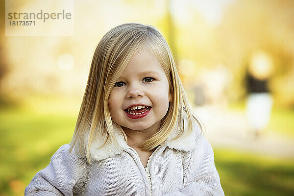 Young girl posing for a portrait in a city park during the fall season; St. Albert  Alberta  Canada