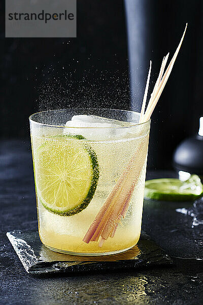 Zitronengras-Cocktail mit Limette auf schwarzem Hintergrund