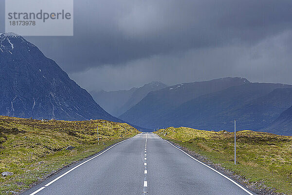 Landstraße mit dunklem bewölktem Himmel im Hochland auf der A82 in Glen Coe  Schottland  Vereinigtes Königreich
