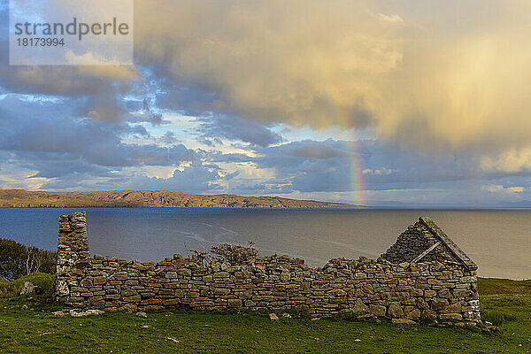 Überreste eines Steinhauses auf der Isle of Skye mit einem Regenbogen  der über der Küste in Schottland  Vereinigtes Königreich  erscheint