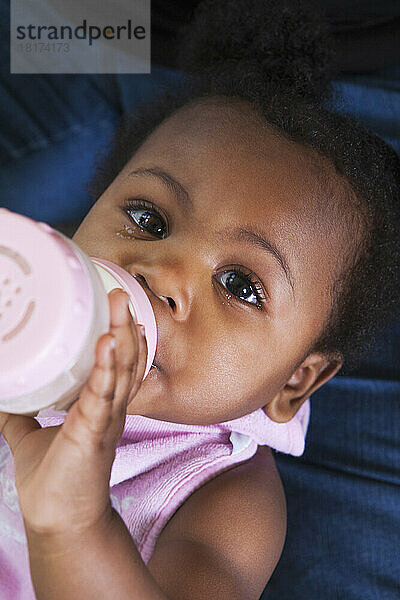 Nahaufnahme eines kleinen Mädchens  das Milch aus einer Flasche trinkt