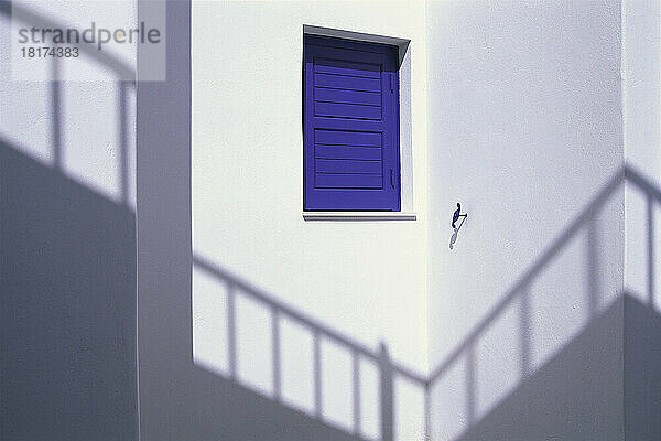 Schatten an der Wand mit Fenster und blauen Fensterläden  Mykonos  Griechenland