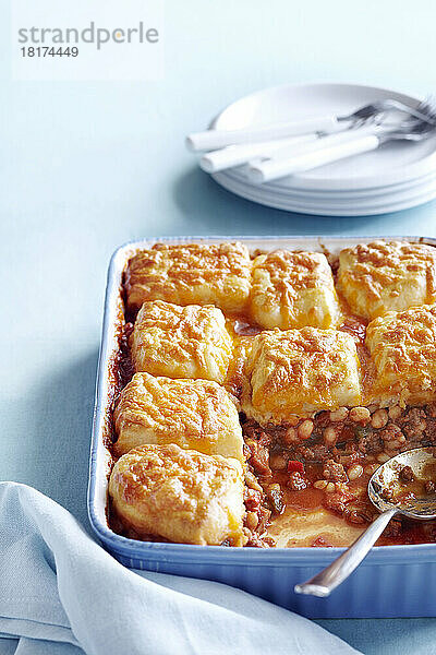 Bohnenauflauf mit Cheddar-Keks-Topping auf blauem Hintergrund