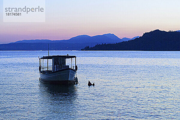 Silhouette eines Bootes am Gardasee (Lago di Garda) in der Abenddämmerung am Gardasee in Venetien  Italien