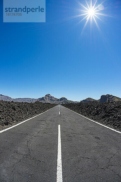 Straße durch Lavafeld mit Sonne im Parque Nacional del Teide  Teneriffa  Kanarische Inseln  Spanien