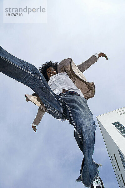 Junger Mann im Freien  der in der Luft gegen den Himmel springt  Mannheim  Deutschland