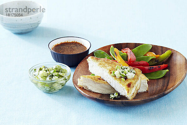 Knusprig gebratener Tofu mit Frühlingszwiebelsalsa  serviert mit sautierten Zuckerschoten und Paprika und einer Dip-Sauce