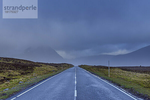 Landstraße mit dunklem bewölktem Himmel im Hochland auf der A82 in Glen Coe  Schottland  Vereinigtes Königreich