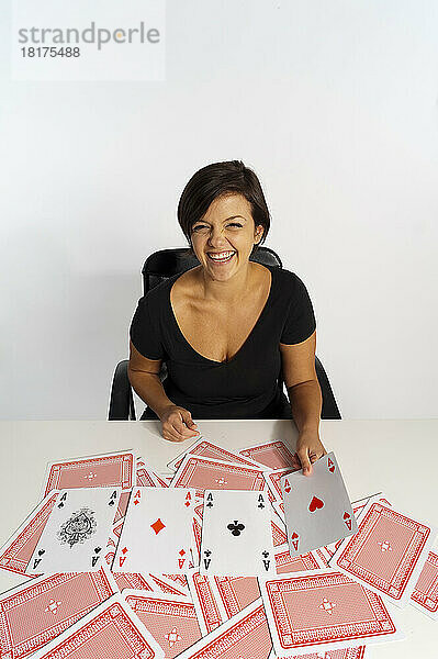 Frau mittleren Alters macht einen Zaubertrick mit einem Kartenspiel