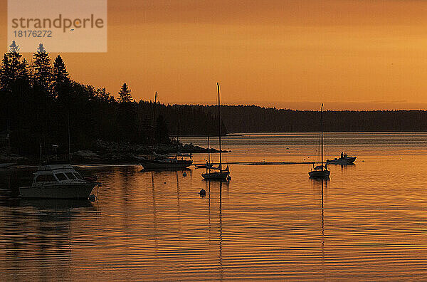 Silhouette Boote im goldenen Sonnenlicht bei Sonnenaufgang.; Runder Teich  Maine.