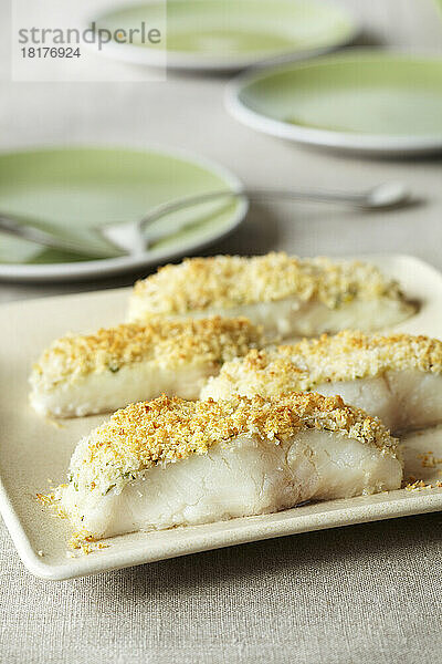 Weiße Fischstücke mit Panko-Kruste auf einer Servierplatte