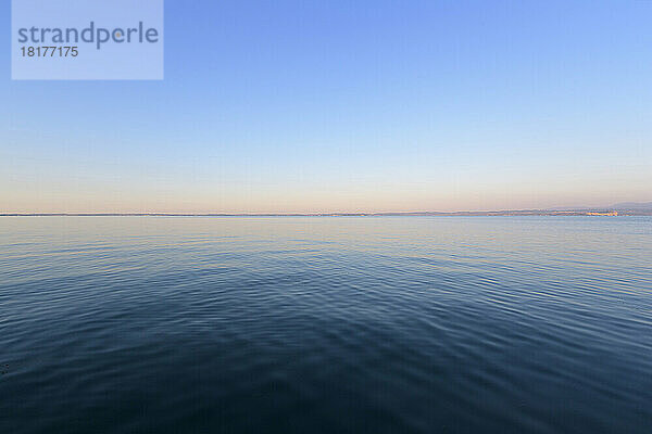Gardasee (Lago di Garda) mit klarem  blauen Himmel im Morgengrauen in Bardolino in Venetien  Italien