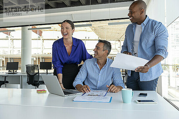 Geschäftskollegen lachen bei Besprechung im Büro