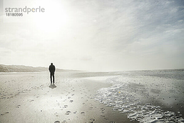 Dänemark  Henne Strand  Person  die alleine am Strand spaziert