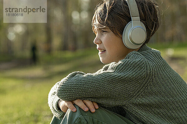 Junge hört Musik über drahtlose Technologie im Park