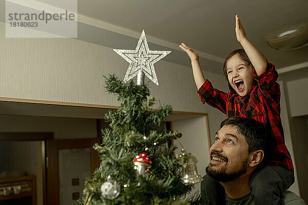 Fröhlicher Sohn und Vater genießen gemeinsam Weihnachten zu Hause