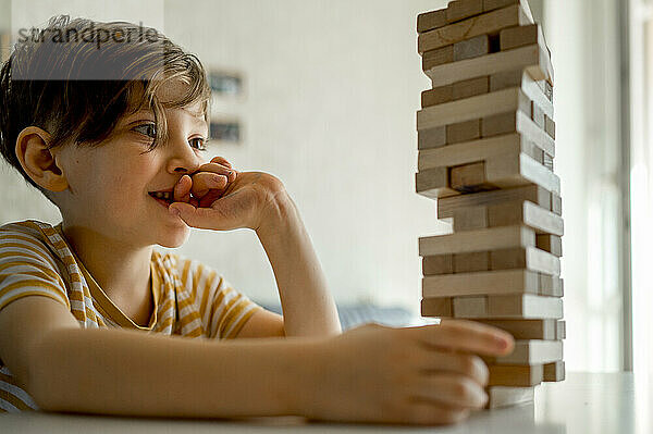 Konzentrierter Junge spielt zu Hause Blockentfernungsspiel