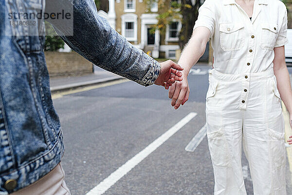 Frau gibt einem Freund auf der Straße die Hand