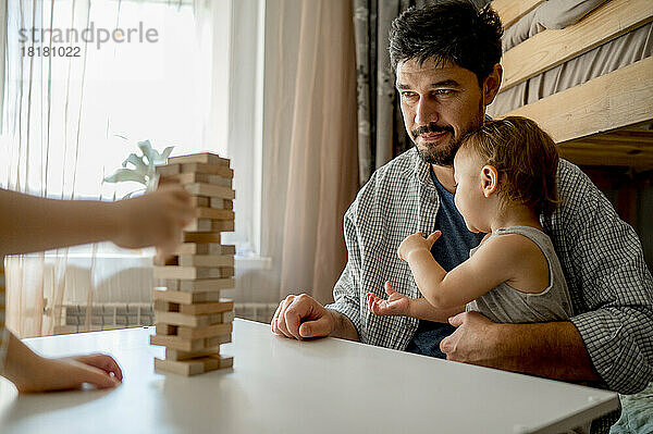Vater und Sohn schauen sich zu Hause auf dem Tisch ein Blockentfernungsspiel an