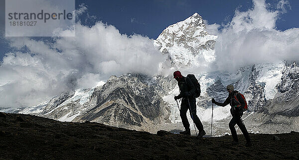 Mann und Frau beim Trekking mit Mt. Everest  Nuptse und Kala Patthar im Hintergrund  Himalaya  Solo Khumbu  Nepal