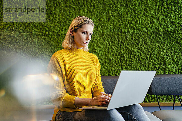 Geschäftsfrau arbeitet am Laptop und sitzt im Büro