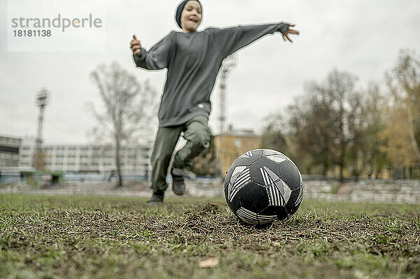 Junge spielt Fußball auf dem Feld