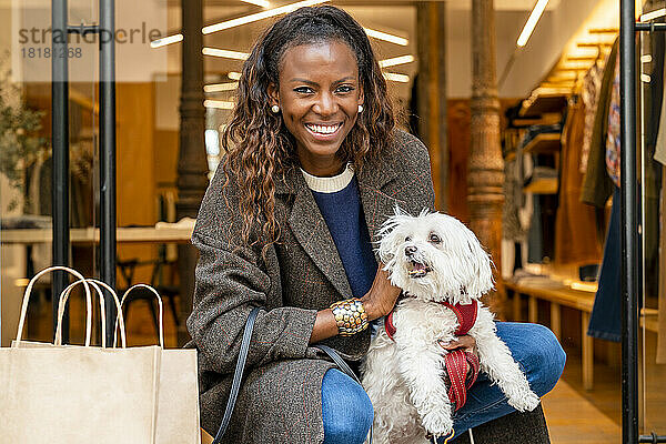 Glückliche Frau mit Hund vor der Boutique