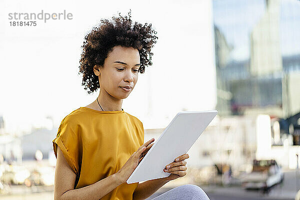 Geschäftsfrau mit lockigem Haar nutzt Tablet-PC