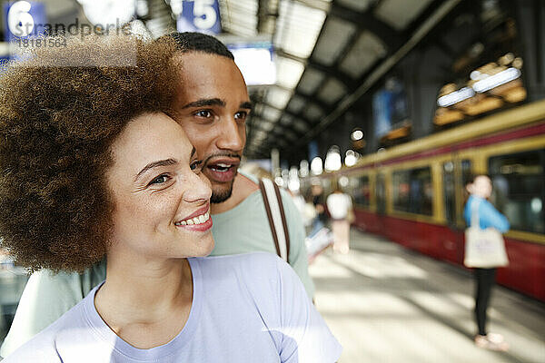 Happy young couple waiting for commuter train