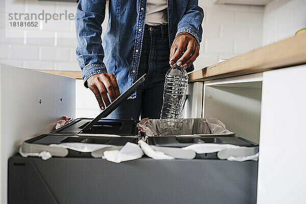 Junge Frau recycelt Plastikflaschen in der heimischen Küche