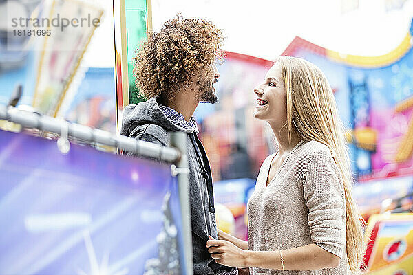 Glückliches Paar auf einem Karussell auf einem Jahrmarkt