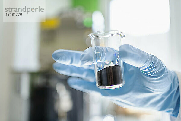 Hand eines Wissenschaftlers  der Gummi im Labor recycelt
