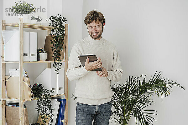 Handsome businessman using tablet PC in office