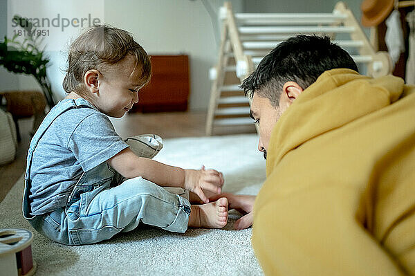 Vater spielt mit Sohn zu Hause auf dem Teppich