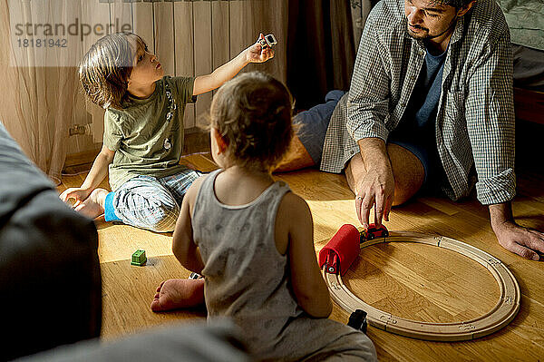 Vater und Söhne verbringen ihre Freizeit damit  zu Hause mit Spielzeug zu spielen