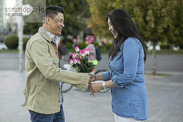 Glücklicher Mann  der Frau am Valentinstag Blumen schenkt