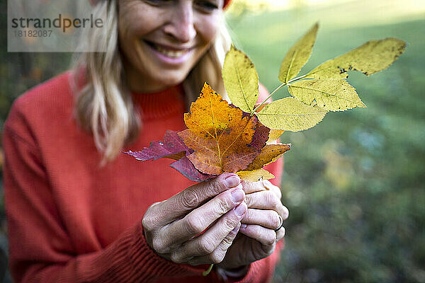Reife Frau hält Herbstblätter