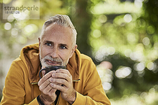 Nachdenklicher reifer Mann sitzt mit Kaffeetasse