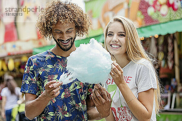 Junges Paar isst Zuckerwatte auf einem Jahrmarkt