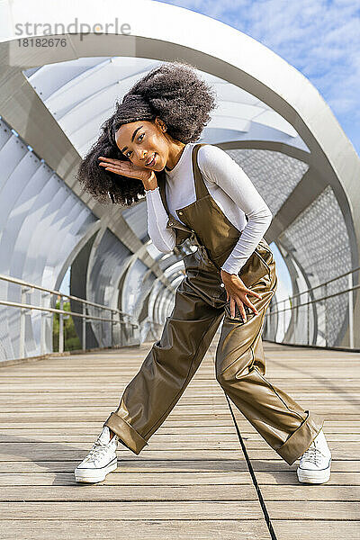 Junge Frau tanzt auf öffentlicher Brücke