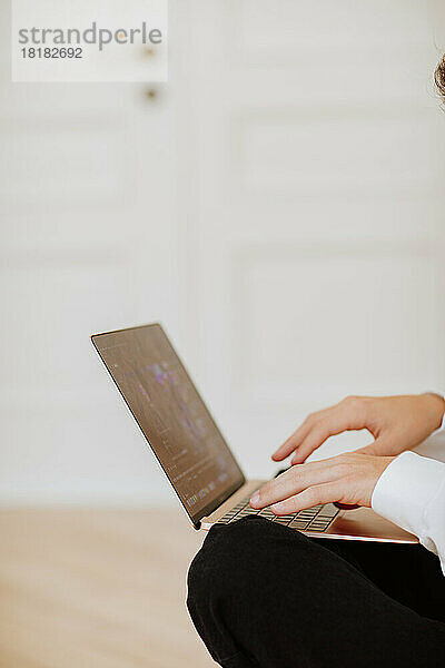 Hände eines Jungen  der zu Hause Spiele auf dem Laptop spielt