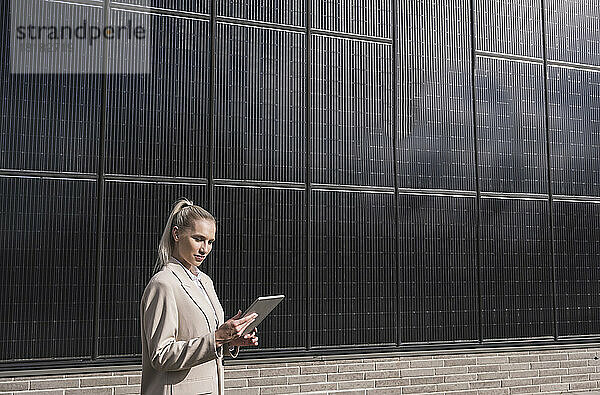 Geschäftsfrau nutzt Tablet-PC vor Sonnenkollektoren