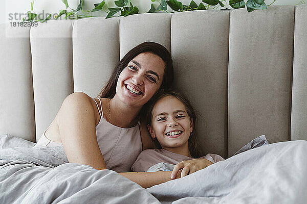Glückliche Mutter und Tochter entspannen sich im Bett