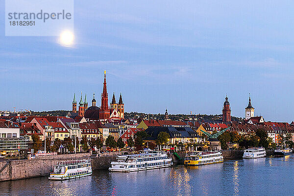 Deutschland  Bayern  Würzburg  Mond leuchtet über dem Main mit dem Würzburger Dom und der Marienkapelle im Hintergrund