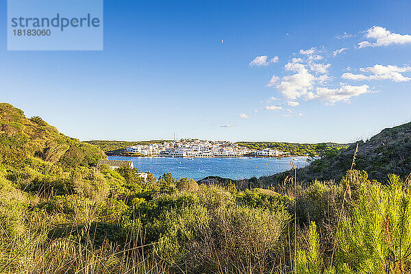 Spanien  Balearen  Menorca  Küstendorf im Sommer von einem grasbewachsenen Hügel aus gesehen