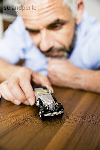 Mann spielt mit Spielzeugautos